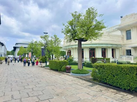 Tourists walking on a paved stone path towards classical architectural Foto stock