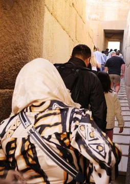 Tourists walking through an ancient stone passageway Stock Photos