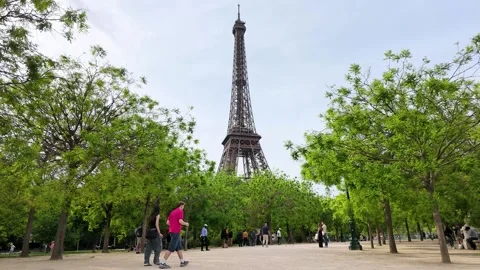 Tourists Walking Through Green Park Near the Eiffel Tower in Paris Stock Footage 334362441