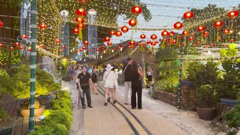 Tourists Walking Through Krabi Night Market Under Red Lanterns and String Lights Stock Footage 334986540