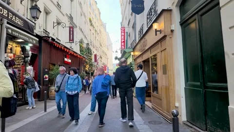 Tourists Walking Through a Narrow Cobblestone Street in Paris France Stock Footage 335854840