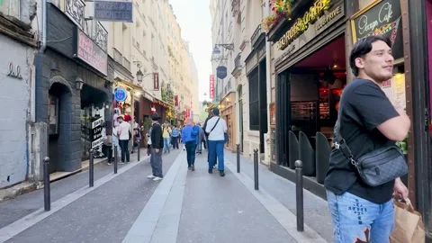 Tourists Walking Through a Narrow Cobblestone Street in Paris France Stock Footage 336524358