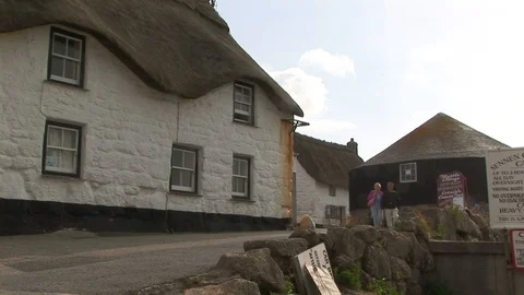 Tourists walking by Tinker Tailor cottage at Sennen Cove Cornwall, England Stock Footage 101490812