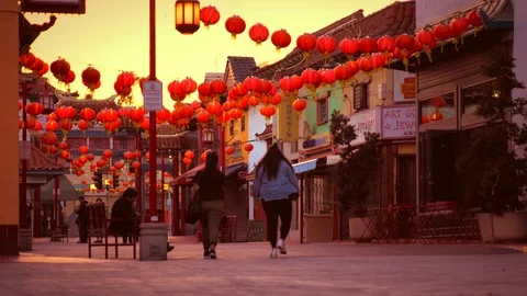 Tourists walking under red lanterns during a china sunset  Stock Footage 89907218