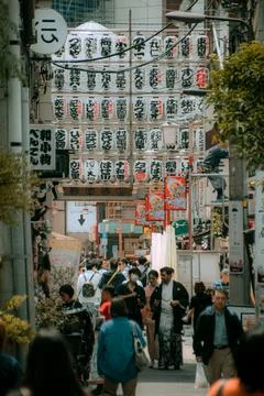 Tourists walking under rows of white paper lanterns in the Asakusa district Stock Photos