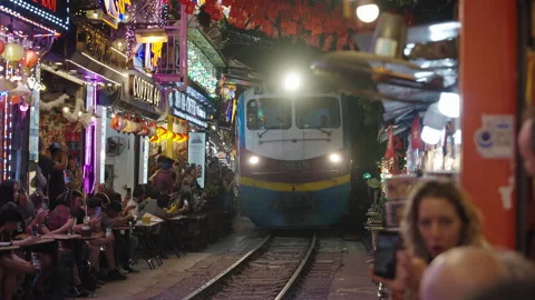 Tourists Watching Train Passing Through Narrow Hanoi Train Street. Stock Footage 323765998