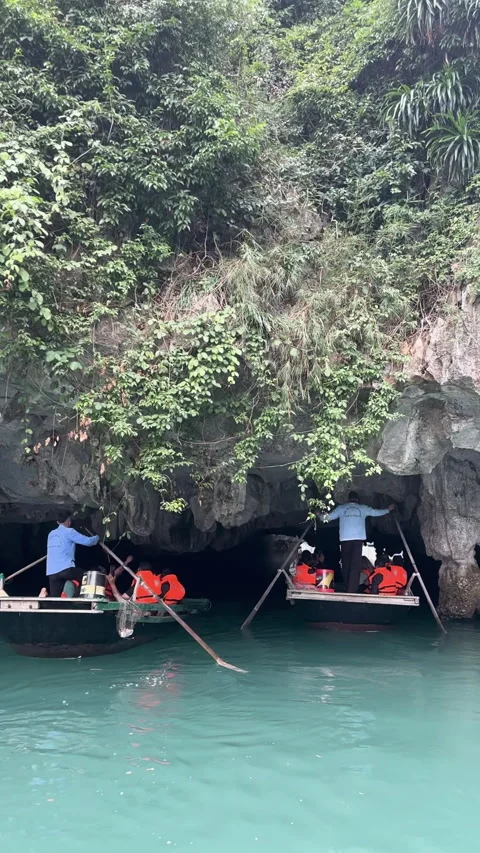 Tourists wearing life jackets on a traditional boat entering a grotto in vietnam Video stock 341754313