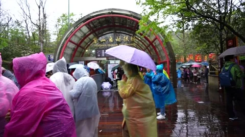 Tourists wearing rain ponchos queueing at Tianmen Mountain entrance Stock Footage 334941705