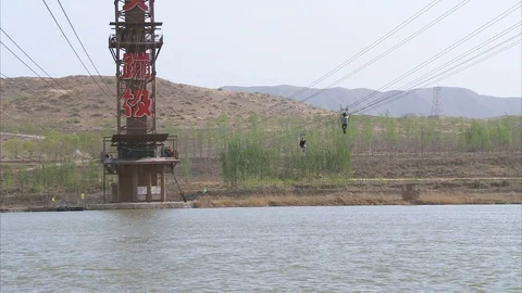 Tourists Zip-line over the river Stock Footage 88337250