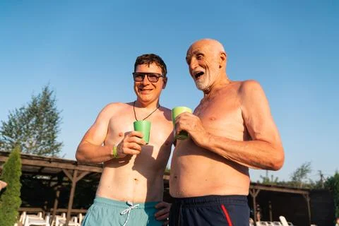 Tow men on the beach drinking cold beverages from plastic cups. Summer manhood Stock Photos