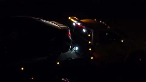 Tow Truck with Car on Flatbed Pulling Away at Night with Lights Flashing Stock Footage 330095992