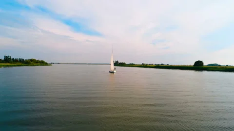 Towards a white sailing boat floating on the river. Copter ( drone ) shooting Stock Footage 119513518