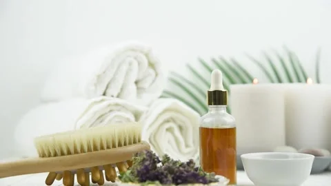 Towel, candles, bottle with natural organic essential oils and massage brush Stock Footage