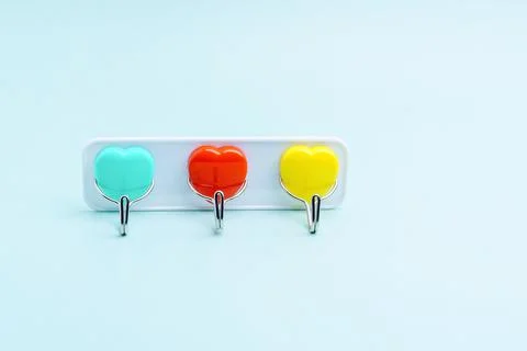 Towel hooks in the shape of hearts of different colors. Three pieces on one b Stock Photos