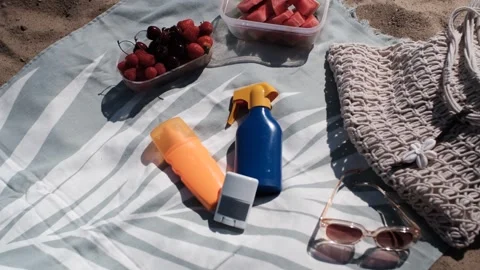Towel layout: sunscreen, bag, sunglasses and fruit 스톡 동영상 313290794