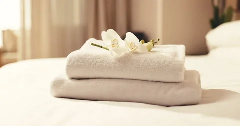 Towel, stack and flowers in bedroom for beauty spa, accommodation or hospitality Stock Footage 345549009
