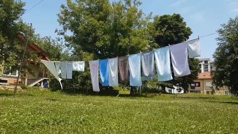 Towels hanging and wind drying in the backyard over the grass Stock Footage 116660729