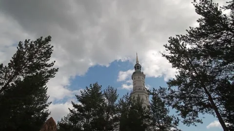 Tower on a background of blue sky and clouds. Coniferous trees. Stock Footage 65331755