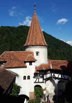 The tower of Bran Castle with the forest in the background Stock Photos