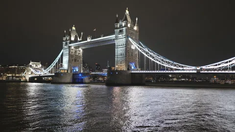 Tower Bridge brightly lit at night, reflecting on the River Thames. Stock Footage 297119470