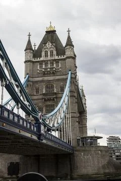 Tower bridge spanning thames river under cloudy sky Stock Photos