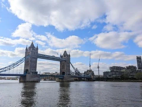 Tower Bridge spans the River Thames under a dynamic cloudy blue sky in London Stock Photos