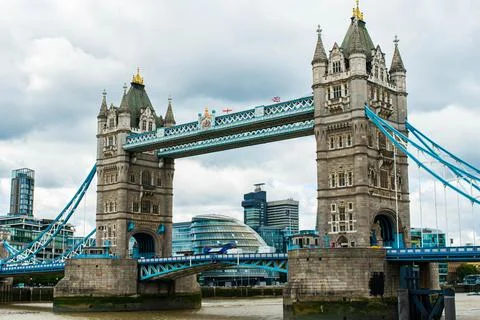 Tower Bridge spans the Thames River under a cloudy London sky Stock Photos