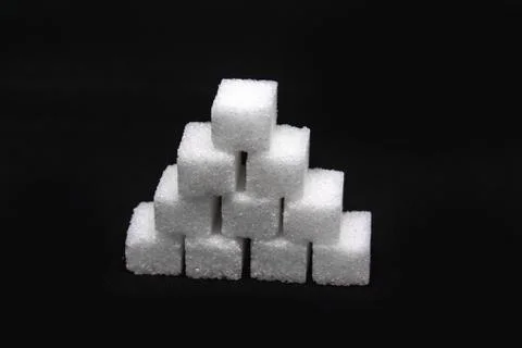 Tower built out of sugar white cubes on isolated black background Stock Photos