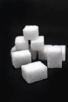 Tower built out of sugar white cubes on isolated black background Stock-Fotos