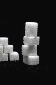 Tower built out of sugar white cubes on isolated black background Stock-Fotos