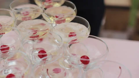 Tower of champagne glasses with two bottles on the table. The waiter pours Stock Footage 196006450