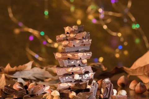 Tower of chocolate chunks with hazelnuts and leaves Stock Photos