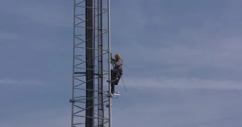 Tower climber climbs down a cell tower using safety harness, belt and ropes Stock Footage 68420216
