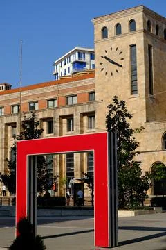 Tower with clock and red doors in the square. Stock Photos