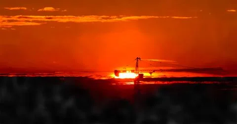 Tower crane against the backdrop of the setting sun. Watercolor illustration. Stock Illustration