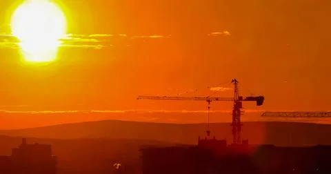 Tower crane against the backdrop of the setting sun. Watercolor illustration. Stock Illustration
