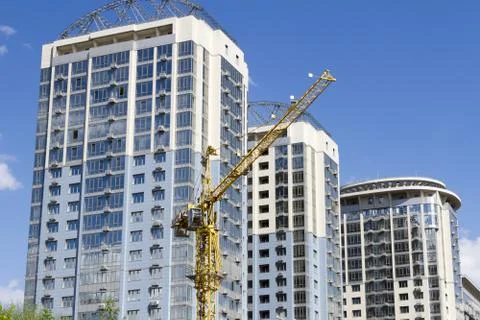 Tower crane against the background of three new high-rise buildings Stock Photos