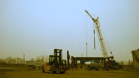 Tower crane and loader work against the blue sky. Evening work. Overtime work. Stock Footage 122657850