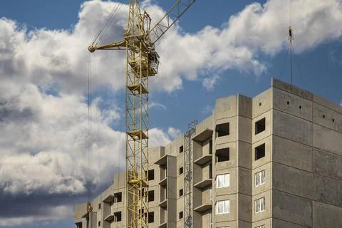 A tower crane assembles gutter panels during the construction of a panel Photos