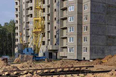 A tower crane assembles gutter panels during the construction 스톡 사진