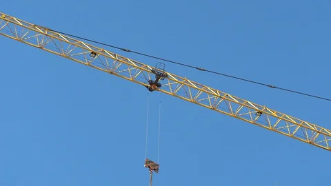 Tower crane on background of blue sky. trolley moves along boom of crane. Stock Footage 114058311