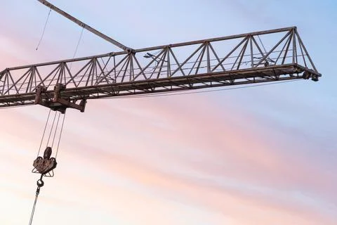 Tower crane on the background of the sky at sunset. The boom of a constructio Stock Photos