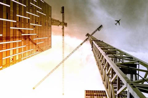 Tower crane. Bottom view of a tall construction cranes next to a modern building Stock Photos