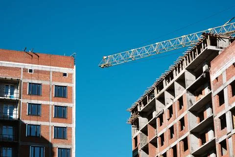 Tower crane at a building site during the construction of blocks of flats. De Stock Photos