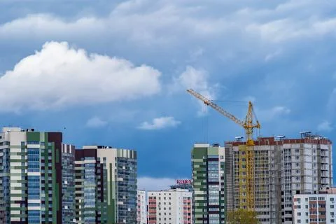 Tower crane builds a monolithic-frame house in a metropolis Stock Photos