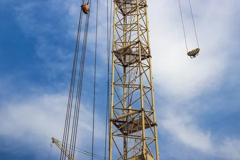 Tower crane close-up on a background of blue sky. Modern housing construction Photos