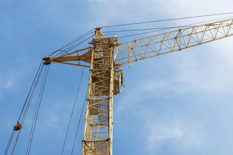 Tower crane close-up on a background of blue sky. Modern housing Photos