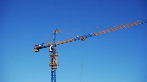 The tower crane at the construction site against the blue sky 스톡 동영상 104924677