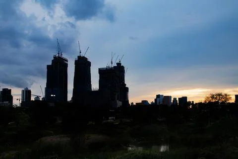The tower crane at the construction site looking from the public park. Stock Photos