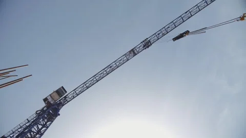 Tower crane lifting materials against clear sky Stock Footage 314235720